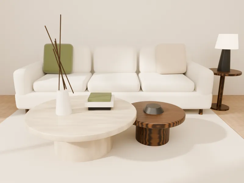 A round stone coffee table and walnut side tables arranged in front of a cream sofa
