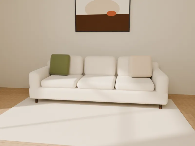 An ivory three-seater sofa with cushions below wall art